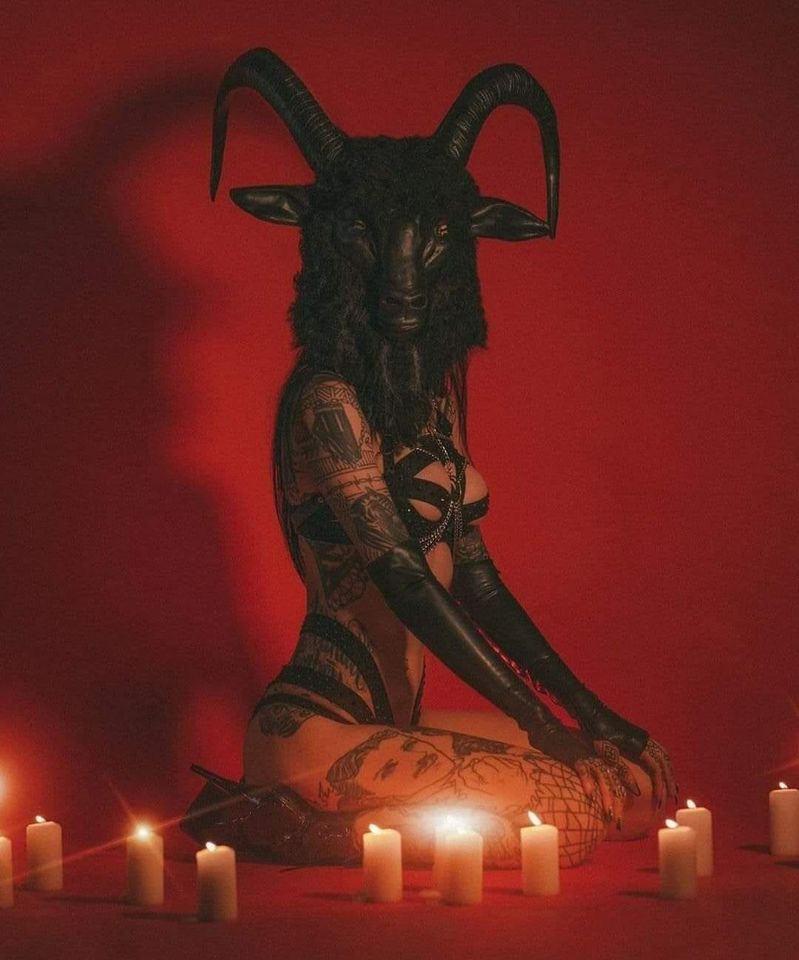 Woman in bondage gear with a goats head