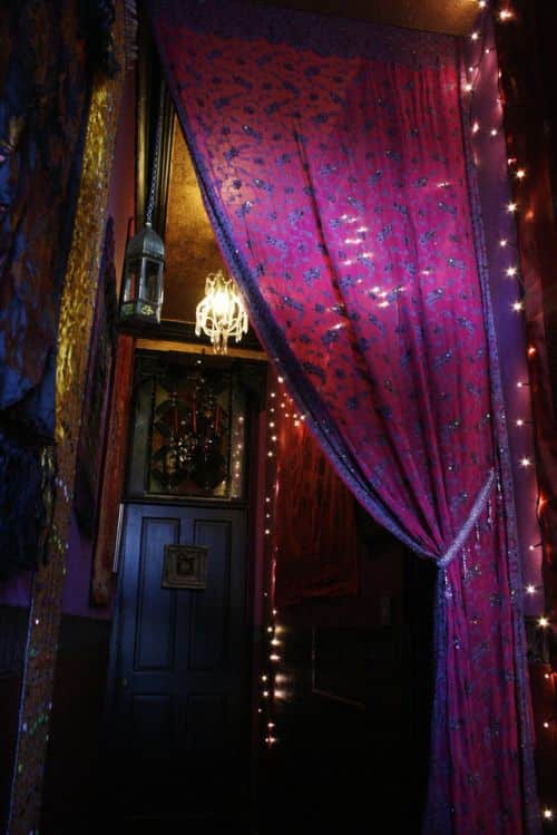 Image of a beautiful dark hallway with exotic soft furnishings and a purple curtain