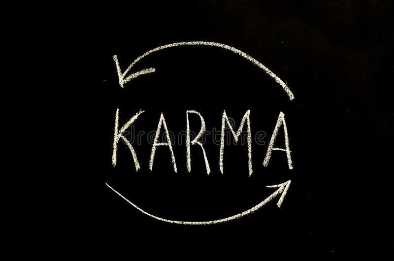 The word "Karma" written in chalk on a black background, with arrows drawn representing a cycle.